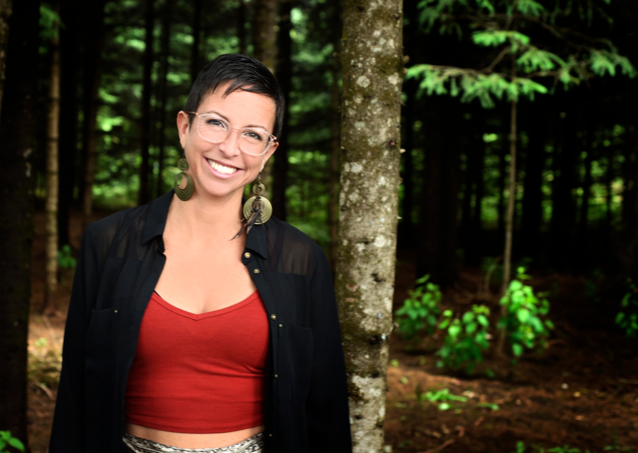 femme rayonnante avec chandail rouge sur fond de nature