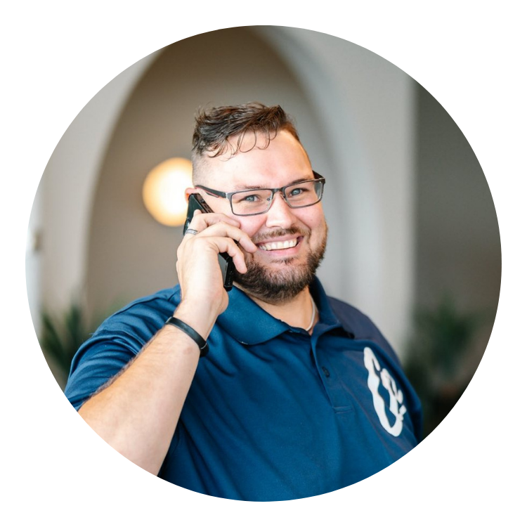 homme souriant, téléphone à la main, chandail bleau avec coeur