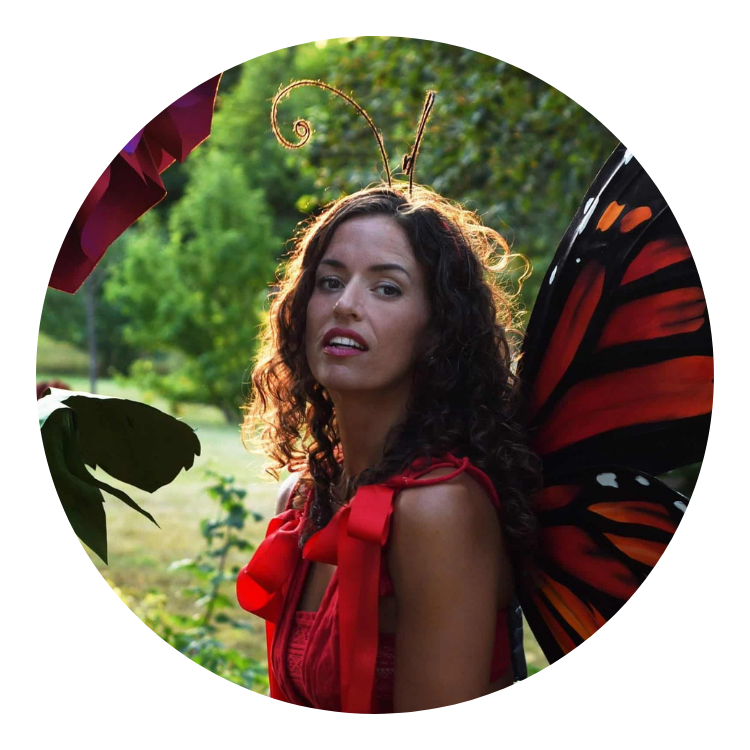 femme avec ailes de papillon devant fleur rouge