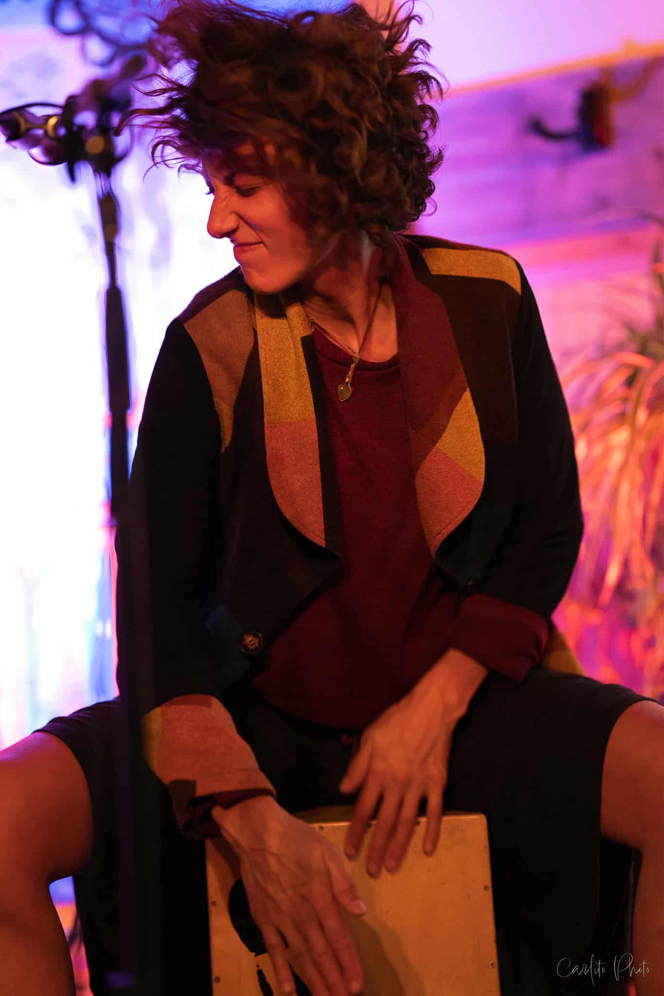 Femme qui joue du tambour dans une ambiance lumineuse colorée