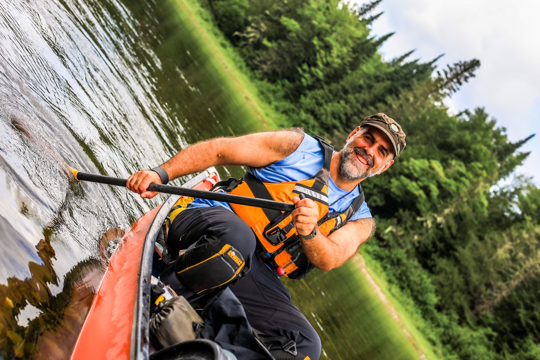Homme souriant avec pagaie dans un canot