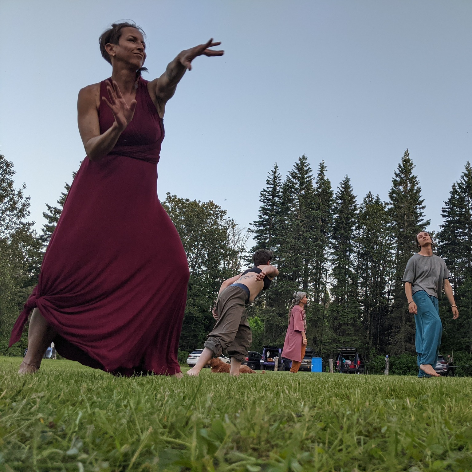 Femme en robe rougeatre qui danse librement dans la nature