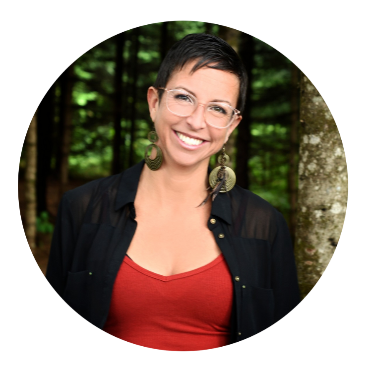 Femme souriante avec chandail rouge et boucles d'oreillles sur fond de nature verte