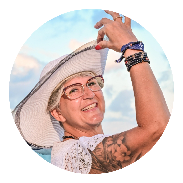 femme souriante, chapeau soleil sur fond de nuages bleus